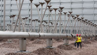 A man and a woman working on development of the Golden Triangle Polymers Company plant