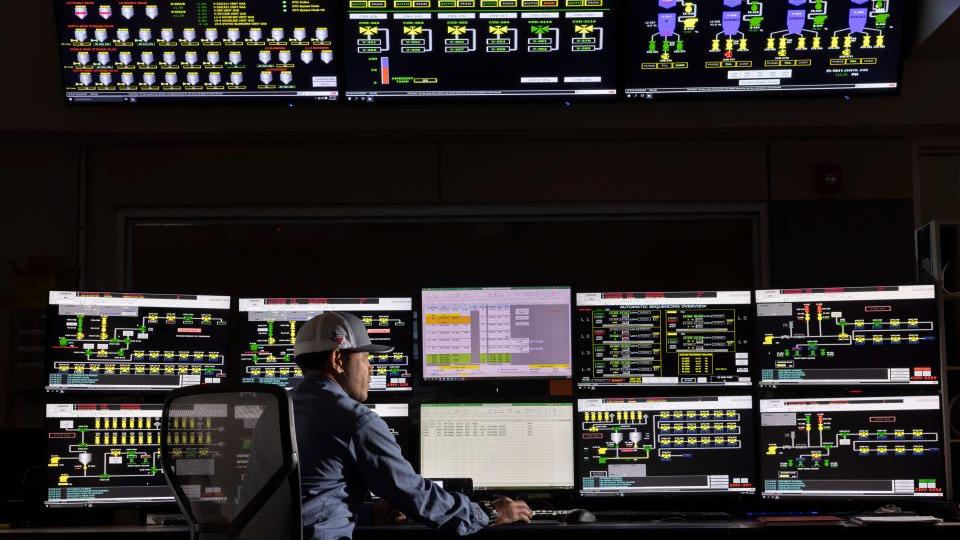 Employee working with multiple computer screens 